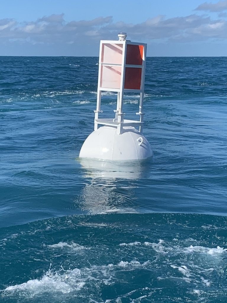 58/14 steel smart buoy, a 58 inch white steel channel marker buoy with orange and white dayboard tower, built-in radar reflector and light, on station offshore