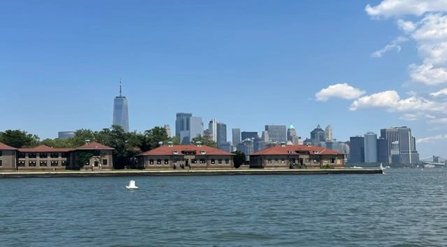 White buoy in New York Harbor off Ellis Island with the historic buildings and Lower Manhattan skyline beyond