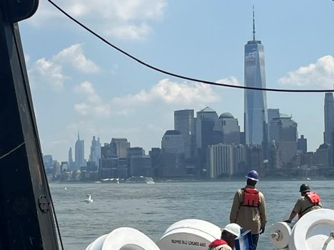 Wet Tech Energy mooring crew on deck among buoy components with the Lower Manhattan skyline behind them
