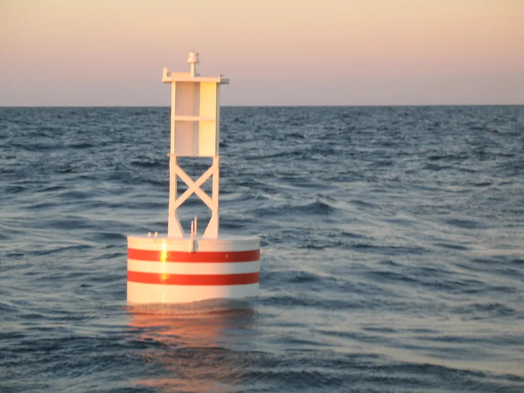 BL 620 lighted steel buoy, white with red bands, with LED lantern on its welded tower on station offshore