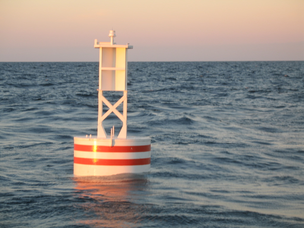 BL 620 6 ft x 20 ft white steel buoy with red bands and LED lantern on station offshore