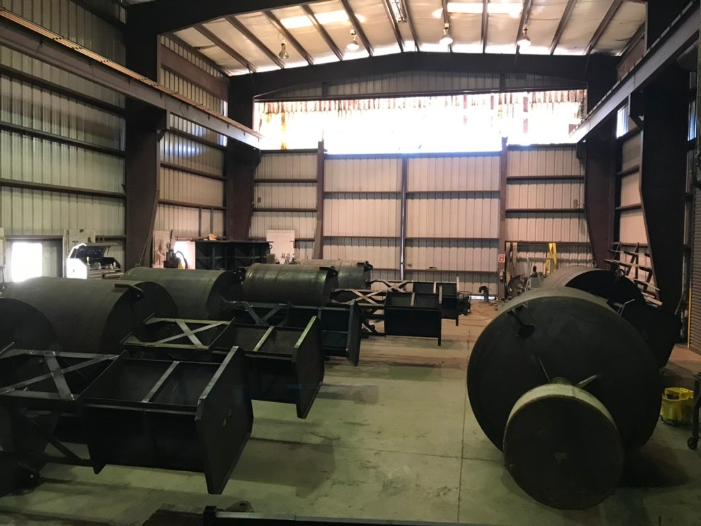 Bare-steel BL 620 buoy hulls and tower frames on the floor of the Wet Tech fab shop in Maurice, Louisiana